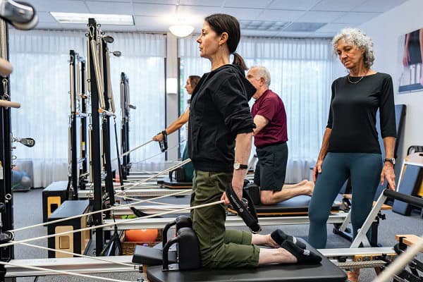 Pilates instructor guiding a client through balance training on the reformer at Pacific Northwest Pilates