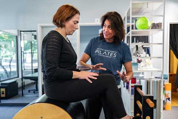 Pilates instructor demonstrating an exercise on the Ladder Barrel at Pacific Northwest Pilates in Portland